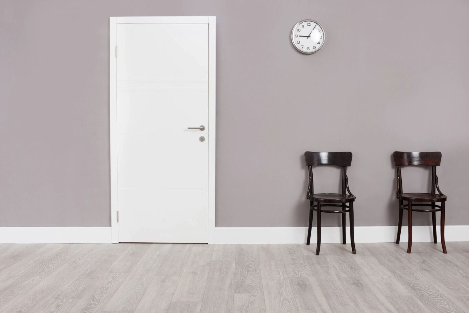 A white door and chair in front of a wall.